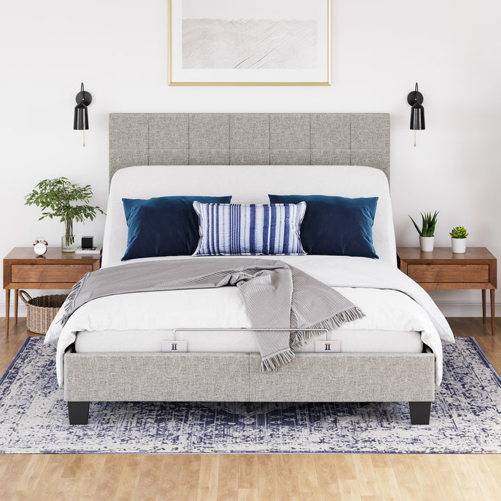 An adjustable power base bed frame with head up, with a white comforter, and pillows in a bedroom setting.