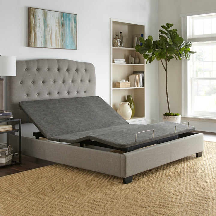 queen size adjustable power base with head and foot raised inside a platform bed frame in a simple bedroom setting