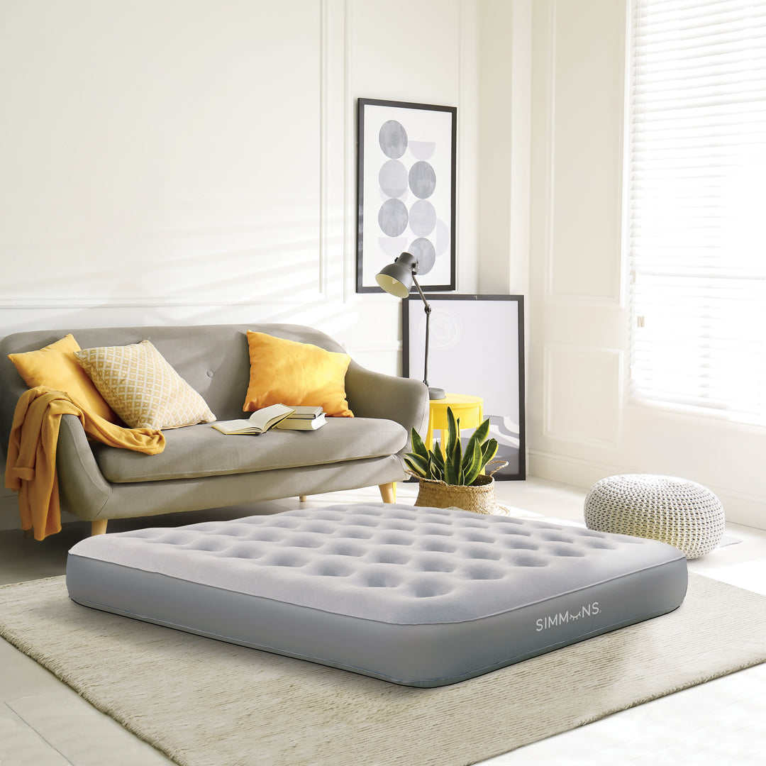 Inflatable Simmons mattress in a living room setting with a couch and decor.