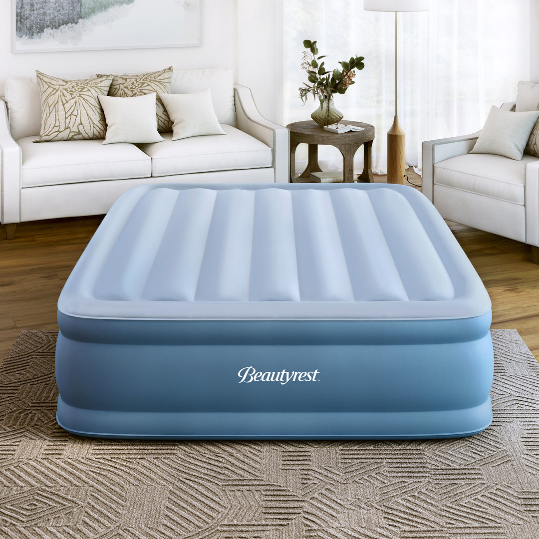 Inflatable air mattress with 'Beautyrest' branding in a living room setting.