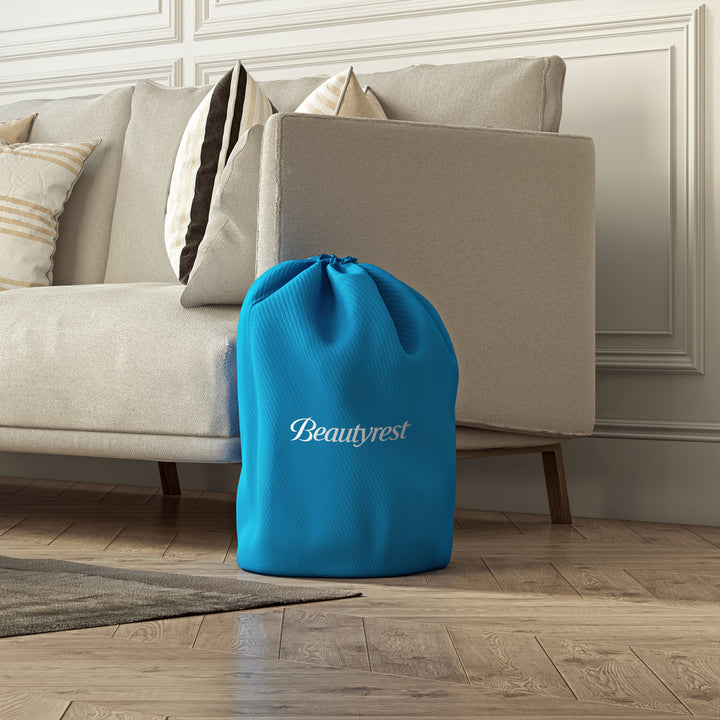 Blue Beautyrest bag on a wooden floor with a beige sofa in the background